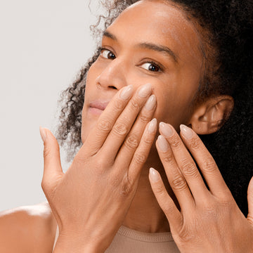 Woman applying Dr. Few Skincare Tinted Mineral Sunscreen onto face